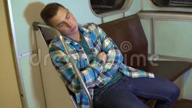 一个年轻人在地铁火车上睡着了。 旧地铁车