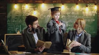天才儿子教母父学生.. 小孩子和女人和男人一起玩老师。 一家人一起在黑板上