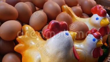 靠近鸡蛋的陶瓷鸡。 特写可爱的陶瓷鸡放在巨大的篮子里，里面放着一堆新鲜的鸡蛋。