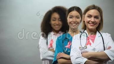 带着粉色丝带微笑的多种族护士，国际乳腺癌组织