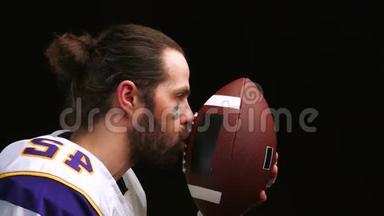 美国足球运动员，在比<strong>赛前</strong>轻轻地握住并亲吻他的球，并在精神上念着祈祷