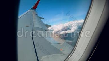 美丽的云彩和一个飞机机翼窗外有一个美丽的蓝天。 从飞机舷窗中射出