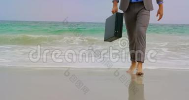 在海滩上，<strong>商务</strong>人员赤脚行走，带着公文包