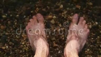 一个赤脚的人站在水中的鹅卵石海岸上，水给他洗了脚，并制定了<strong>应对</strong>计划