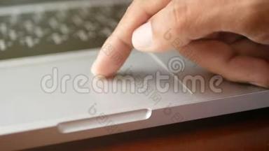 4K. 特写一个男人用手提笔记本电脑，用手指用键盘、触摸板或触控板滑动和放大