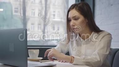 不高兴的女<strong>人</strong>用她的笔记本电脑<strong>坐</strong>在咖啡馆的桌子上。 <strong>坐</strong>在靠近窗户的<strong>沙发上</strong>用电脑工作的女孩