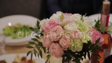 喜庆的餐桌上放着美丽的婚礼花束..