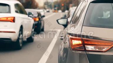 城市道路景观与汽车交通堵塞与特写车辆后停车灯在高峰时间。 许多车辆