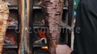 一个厨师切牛肉做沙瓦玛，陀螺，多纳串。 把肉串上