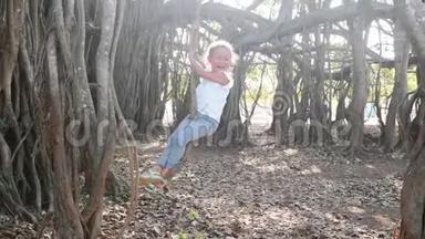小可爱的小女孩慢动作在榕树下的莲娜上摇摆