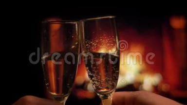 在浪漫的气氛中，两只相爱的情侣手的特写镜头，一副充满香槟酒的闪烁眼镜