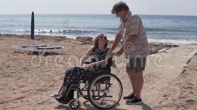一位<strong>老人</strong>载着一位<strong>坐轮椅的</strong>妇女沿着大海