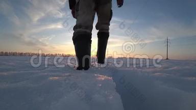 穿暖和的衣服，穿暖和的靴子的男工在寒冷的冬天沿着<strong>电力线</strong>路在雪地里度过