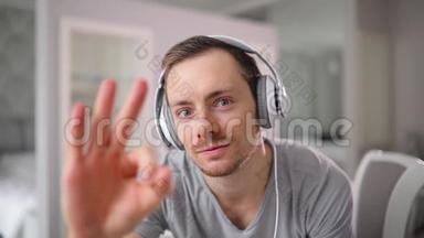 戴耳机的人的肖像，指着OK，竖起大拇指听着好听的歌曲