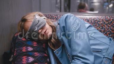 慢动作年轻漂亮的女孩在盲人的眼睛<strong>上</strong>，睡着了<strong>地铁</strong>火车。 头放在背包<strong>上</strong>