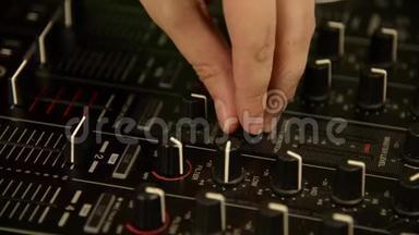 DJ在音乐调音台上演奏。 黑色音乐混合控制台。 快关门。