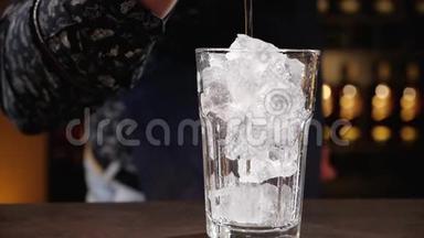 酒保用手把酒倒在杯子里的冰块上