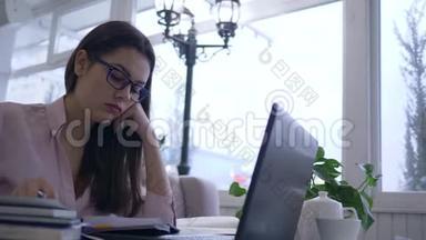 <strong>劳累</strong>过度的女学生变成了戴眼镜的学生，在远程学习时用笔记本电脑上在线课程