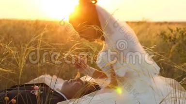 日落时分，新娘和新郎正坐在田野里，端着麦子，互相微笑。 蜜月。 情人