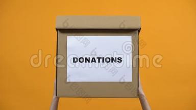 手拿着捐款箱在橙色背景，<strong>人道主义援助</strong>，利他主义