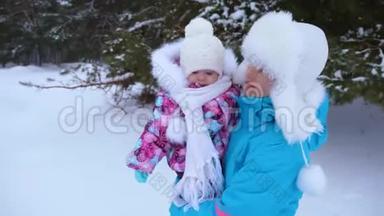 妈妈抱着她的小女儿，在白雪皑皑的<strong>冬松</strong>公园沿路散步，笑了起来。 圣诞周末。 快乐的母亲