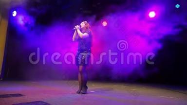 一位年轻的红发歌手，手里<strong>拿</strong>着麦克风，穿着黑色的连衣裙，在舞台上尽情地<strong>唱歌</strong>