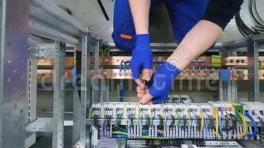 工厂电工工程师用<strong>螺丝</strong>刀安装电缆，将电子箱控制柜中的<strong>螺母</strong>拧紧到