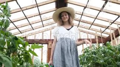 戴着<strong>草</strong>帽，穿着<strong>草裙</strong>的微笑着的女农民带着浇水罐去了温室