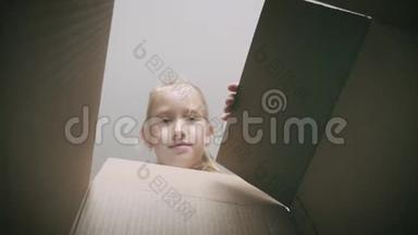 惊讶的女孩<strong>打开</strong>纸箱，<strong>打开</strong>纸箱，看里面。 儿童情感概念。