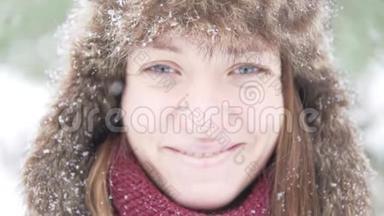一个戴着温暖冬帽的年轻女子正在享受降雪