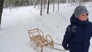 穿暖和衣服的可爱男孩在<strong>下雪</strong>的冬天拉木雪橇。 小男孩在公园里<strong>下雪</strong>。 跟踪