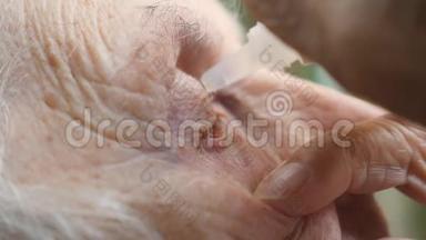 一个老女人滴在眼里的医疗滴。 祖母感染和眼睛发炎的肖像