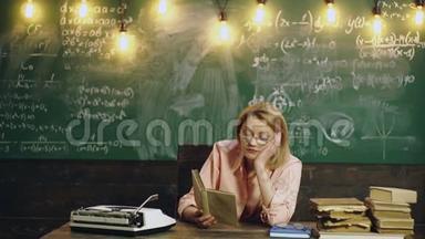 女人在学校<strong>教室</strong>里的绿色黑板背景上读一本书。 <strong>教室</strong>里的老师。 学习概念