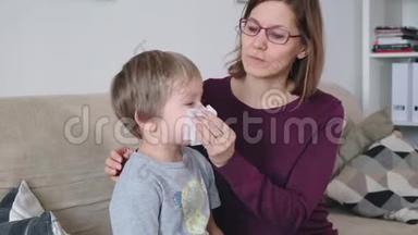 妈妈和小男孩流鼻涕，妈妈照顾她生病的蹒跚学步的男孩。