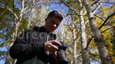一位摄影师拍摄野生自然的照片，看着相机离开相框。