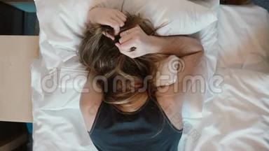 小<strong>贴士</strong>：沮丧的年轻女子脸朝下躺在床上。 哭泣的女孩摇头，愤怒地拉着头发。
