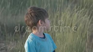 无家可归的孩子独自呆在田里。 一个穿着脏衣服的可爱悲伤的男孩，一张难民肖像上的孤儿脸上的悲伤