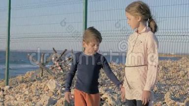 两名贫穷的难民儿童站在战争冲突地区的海边。 等待获救的男孩和女孩