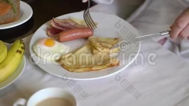 早上吃早餐的女人。 盘子里有<strong>煎鸡蛋</strong>，<strong>煎</strong>饼和香肠。