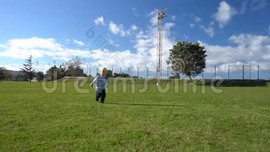 三岁的孩子在足球场上带着球跑
