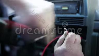 从宏观上看`人的手使用仪器在汽车上的电缆。