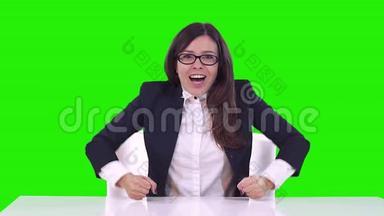 办公室里一个女人<strong>绿</strong>色背景的肖像。 戴眼镜的黑发女人在<strong>工作中</strong>高兴、微笑、跳舞