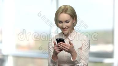 微笑的女人在手机上读<strong>留言</strong>。