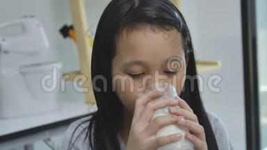 <strong>儿童</strong>亚洲女孩喝一些牛奶在桌子上，舒适的<strong>儿童</strong>在家的概念。
