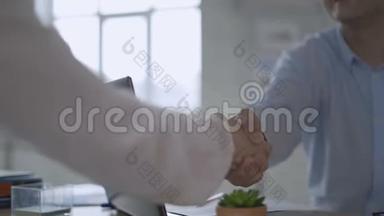 关闭两个商人握手的慢镜头。 经理和他的助手握手