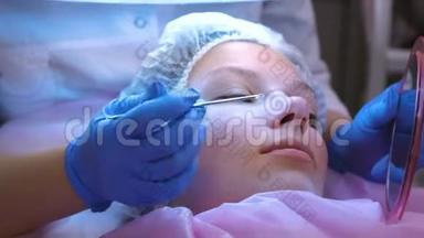 美容师的面部机械清洁。 美容师在病人面前展示她脸上的东西