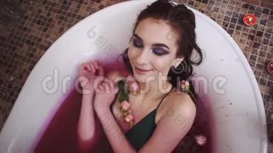 <strong>美丽美丽</strong>的<strong>美丽</strong>的温柔的女人，化妆鲜艳，用玫瑰洗澡。 可爱的女孩在浴室里放松