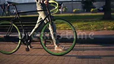 在早晨的公园或街道上，除了一辆<strong>自行车</strong>，还有一个穿着运动鞋的女人走路的镜头。 年轻人的侧视