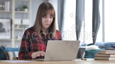 令人震惊的，精神<strong>恍惚</strong>的年轻女孩在笔记本电脑上闲逛和工作