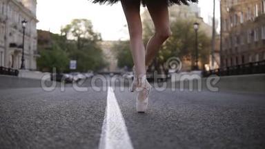优雅的年轻芭蕾舞演员在一条空路上的街道上。 在尖尖<strong>踩</strong>着脚尖。 把一个芭蕾舞女演员`